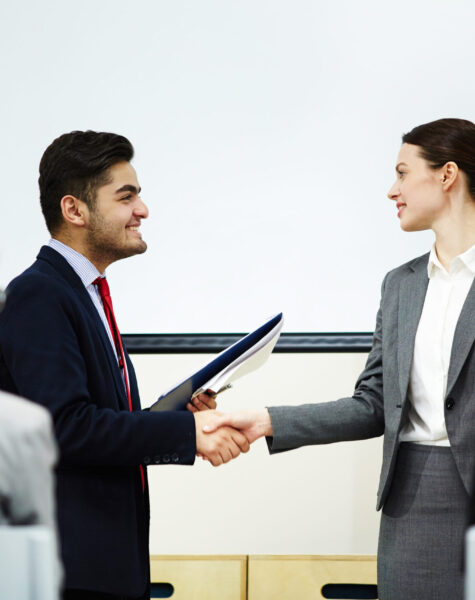 Coach congratulating one of business course attendants on graduation event